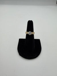 14k This is a yellow gold engagement ring featuring a large round center (Cz) stone and accent diamonds on the band.