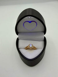 14k This is a yellow gold halo engagement ring with a round center (Cz) stone and a split shank band.