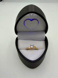 14k This is a yellow gold solitaire engagement ring with a round brilliant cut center stone.