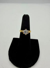 14k This is a yellow gold ring featuring a large, round, clear cubic zirconia (CZ) stone.