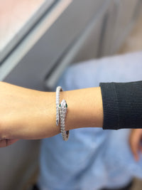 Silver bracelet set with and emerald eyes.