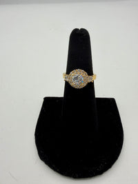 14k This is a round diamond cluster engagement ring with a halo and side stones, set in yellow gold With CZ diamonds